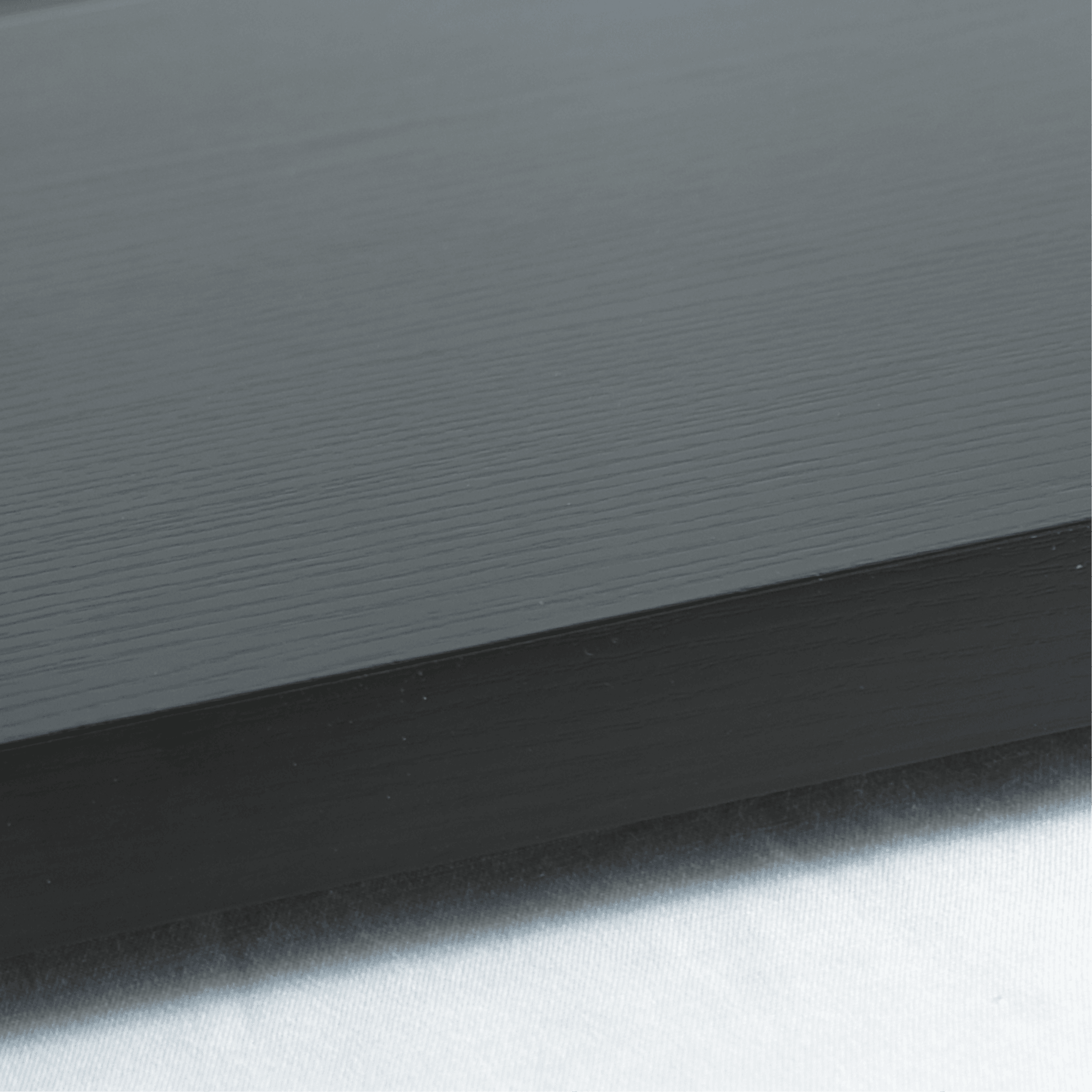 Black woodgrain textured base with smooth one-tier flat glass cover for ambient cake display.