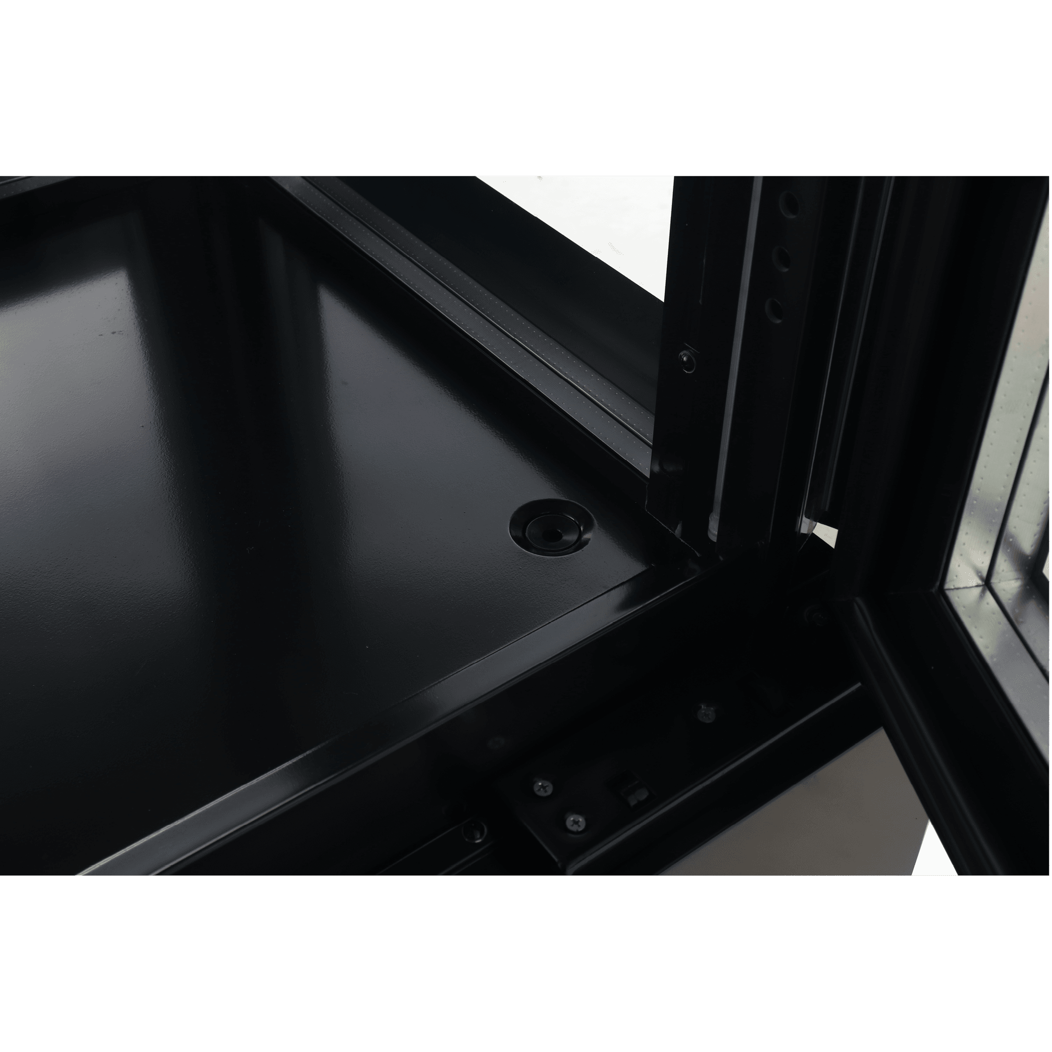 Close-up of black painted steel corner with glass panels and metal framing inside upright display freezer.