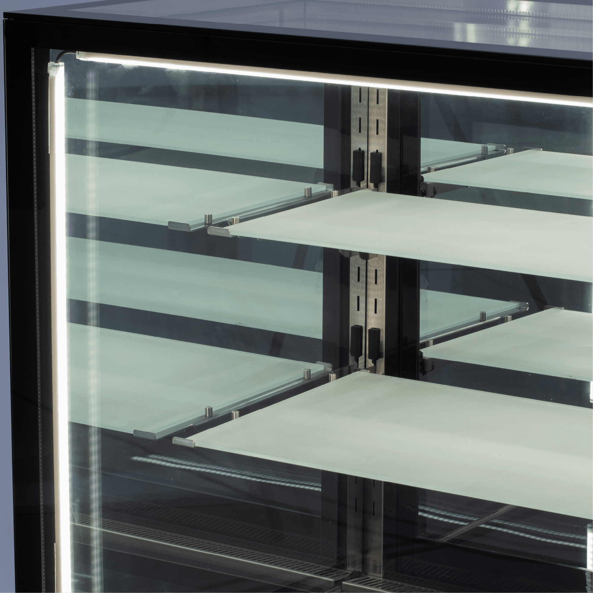 Black stainless steel three-tier refrigerated cake display with glass panels and LED lighting.