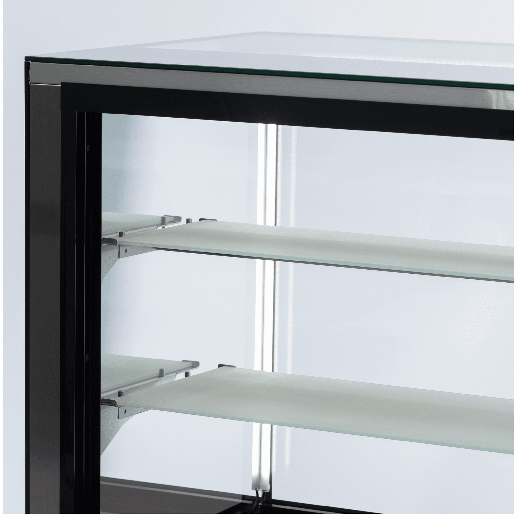 Black stainless steel refrigerated cake display with four white glass shelves and LED lighting.