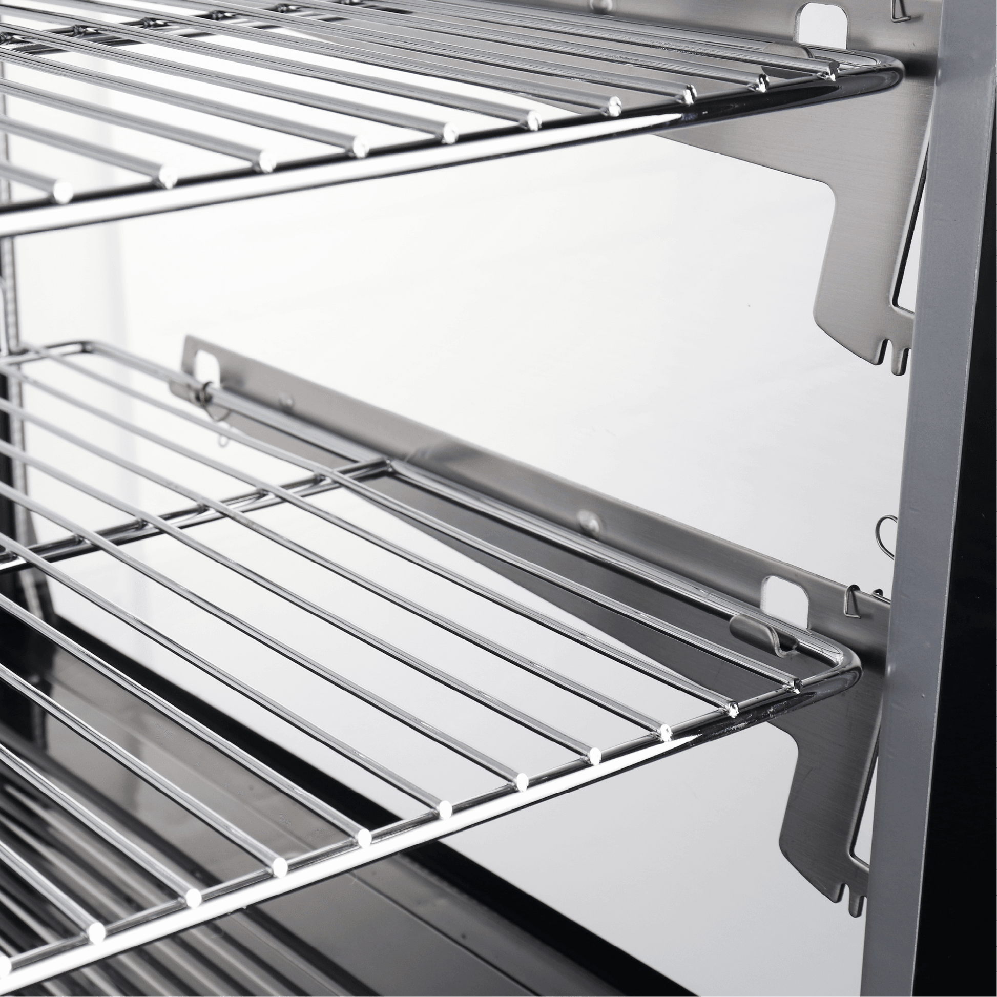 Stainless steel curved interior with wire racks inside a refrigerated cake display unit.