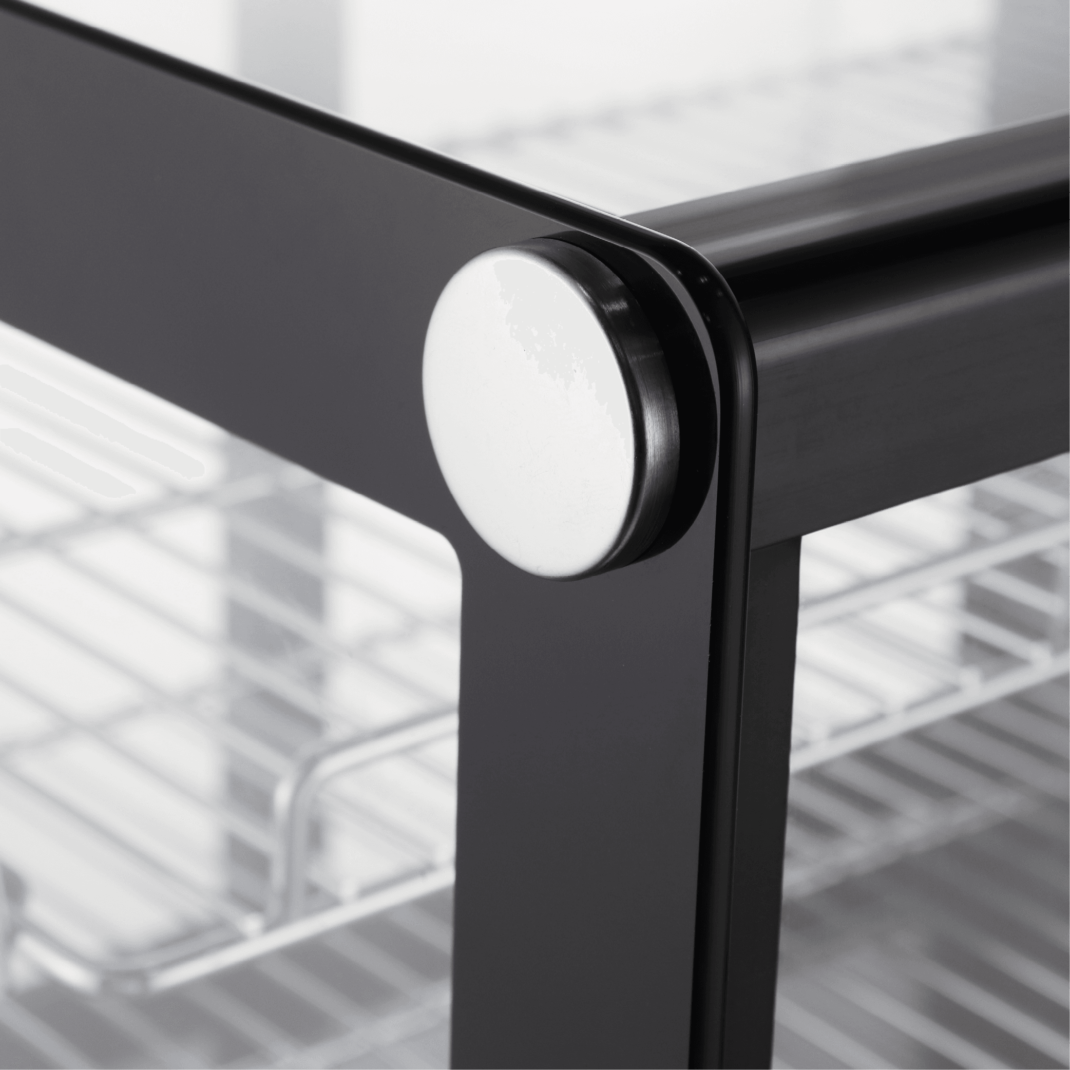 Close-up of black metal frame corner with round silver accent on Exquisite CTC120S cake display refrigerator.