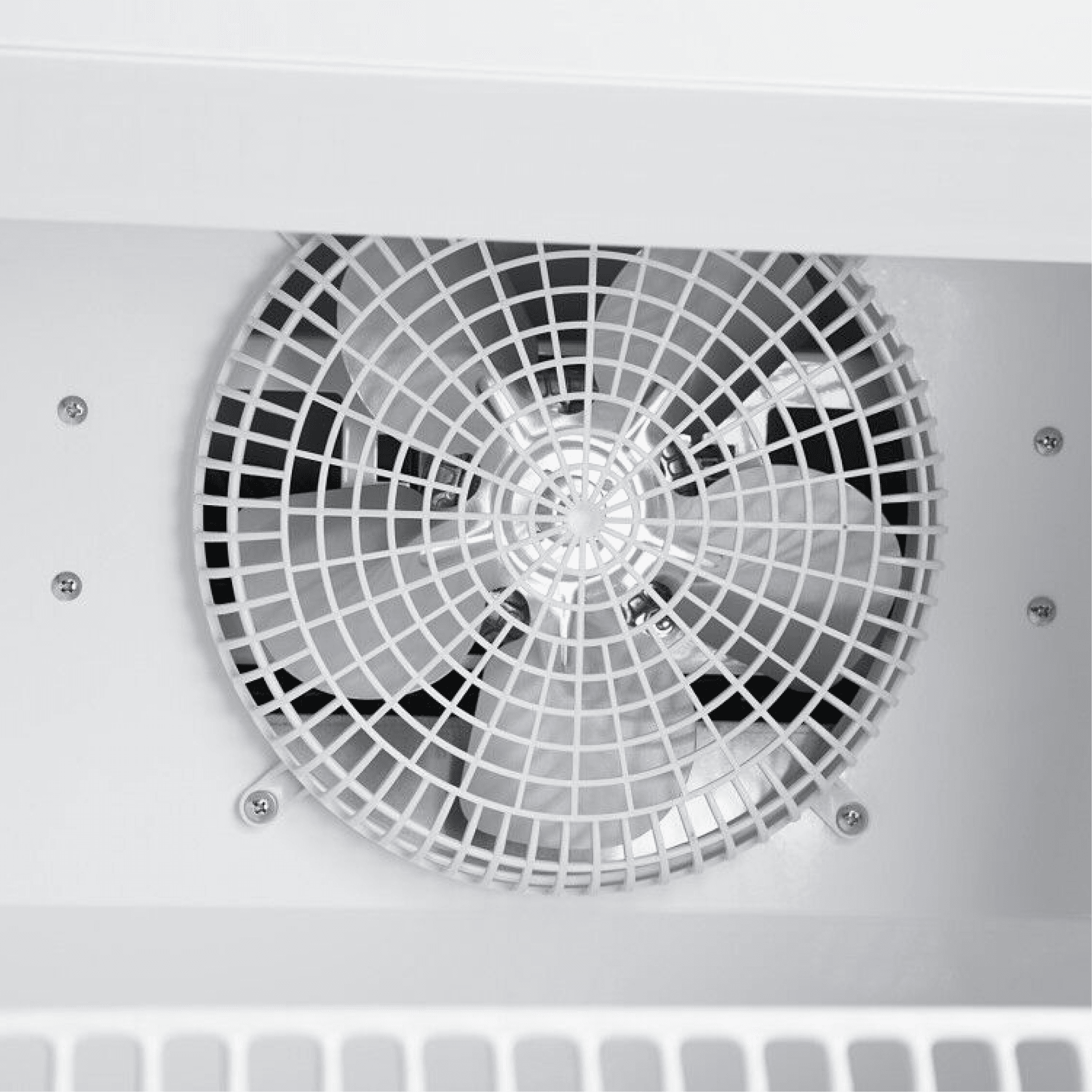Close-up of white painted steel fan grille inside an upright glass door display refrigerator.