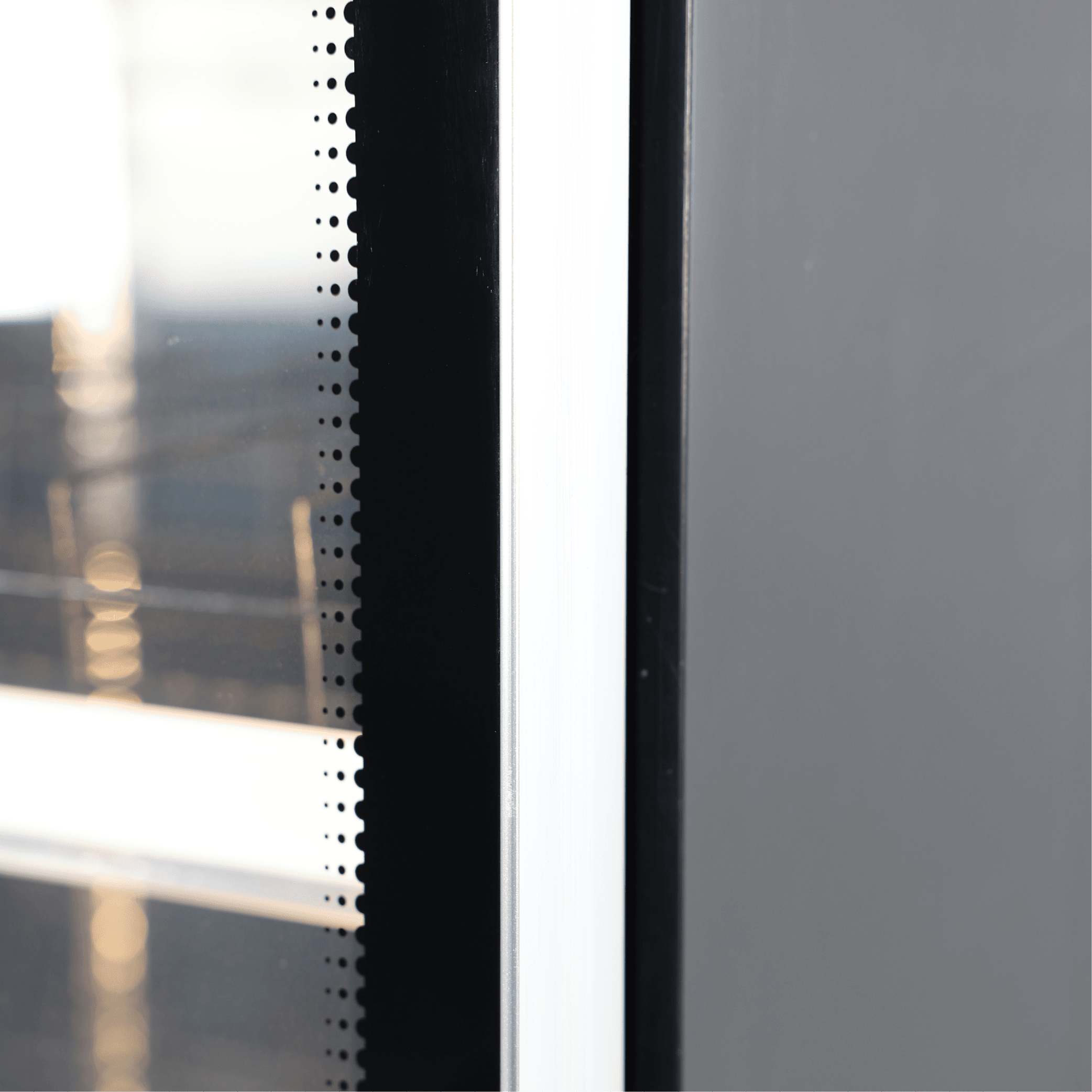 Black upright display fridge with one glass door, painted steel frame, and internal shelving visible through glass.