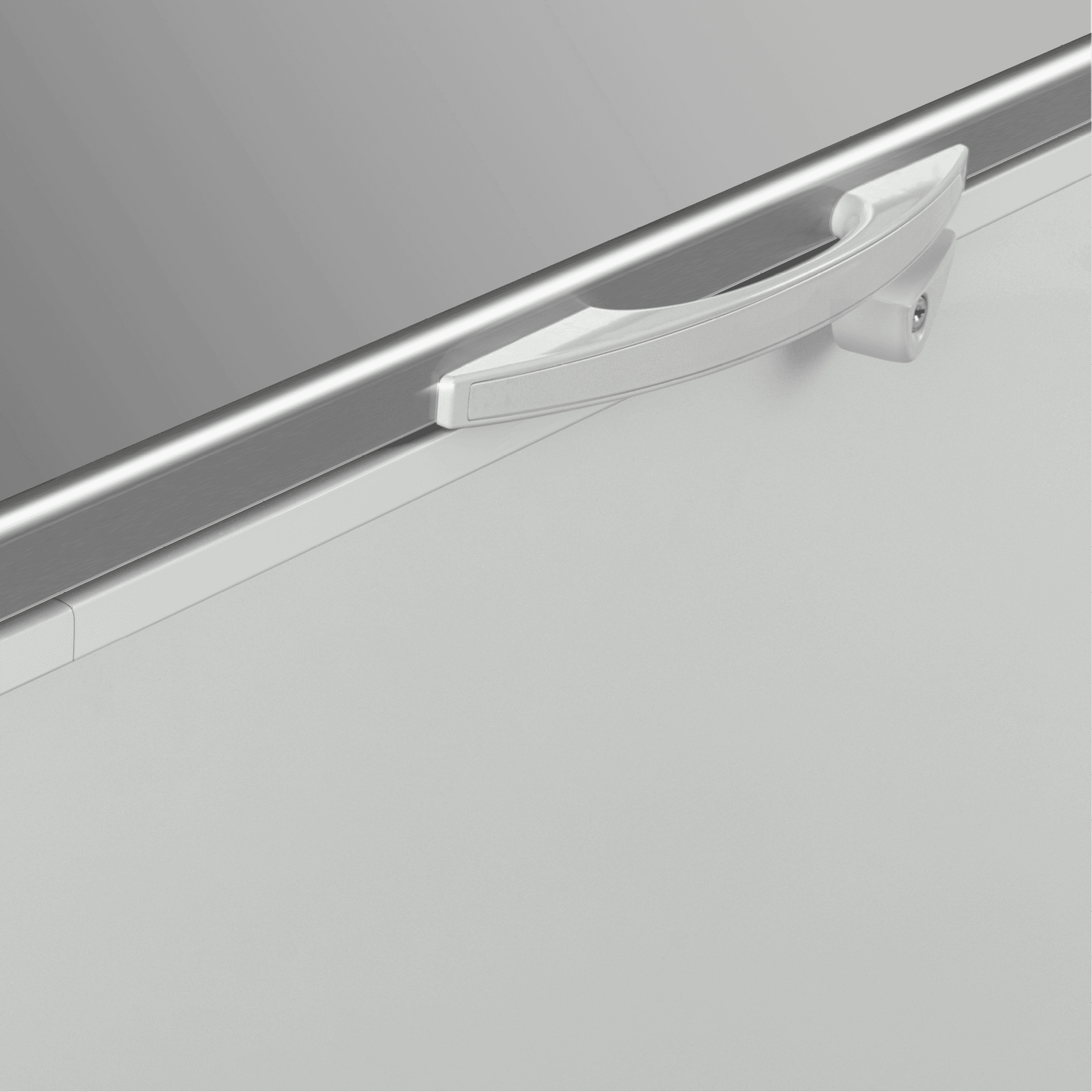 White painted steel handle on a stainless steel top panel of a chest freezer door.