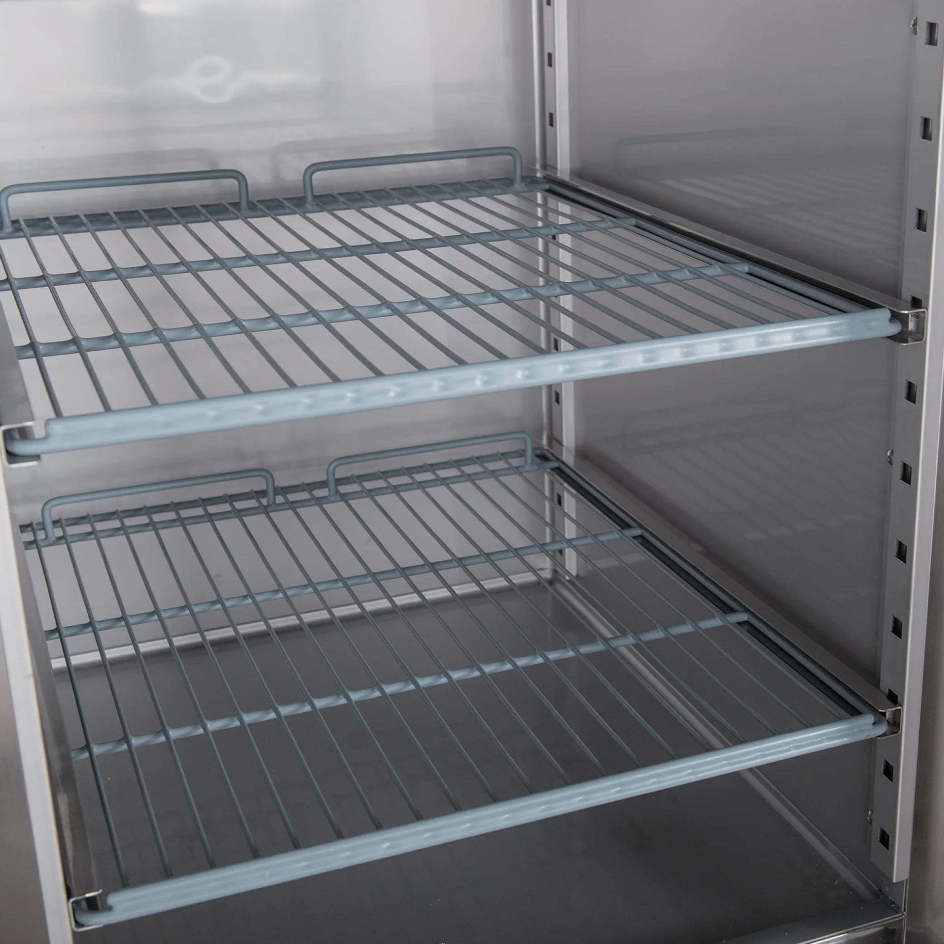 Interior view of stainless steel upright fridge with two adjustable wire shelves and smooth walls.