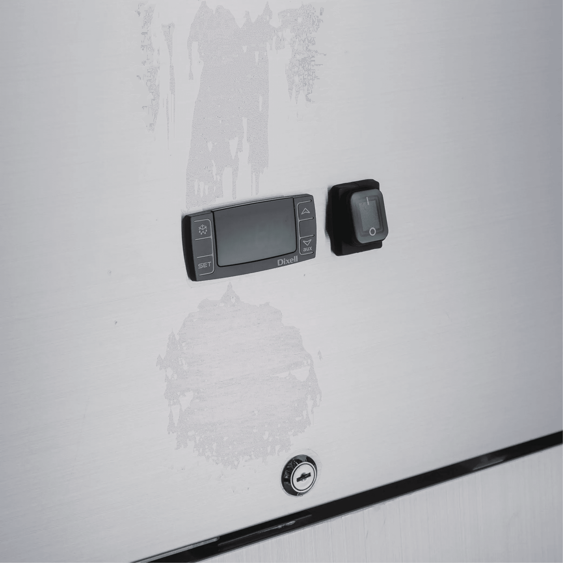 Close-up of stainless steel freezer door with digital control panel, switch, and key lock.