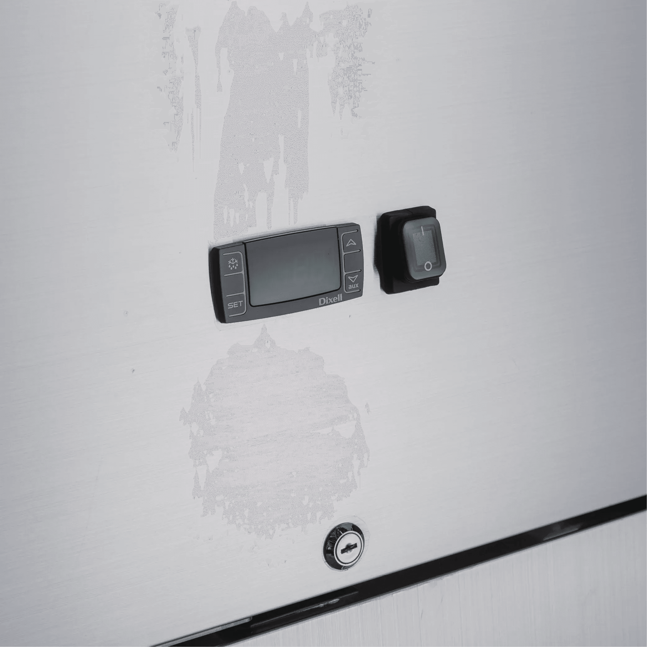 Close-up of stainless steel freezer door with digital control panel, switch, and key lock.