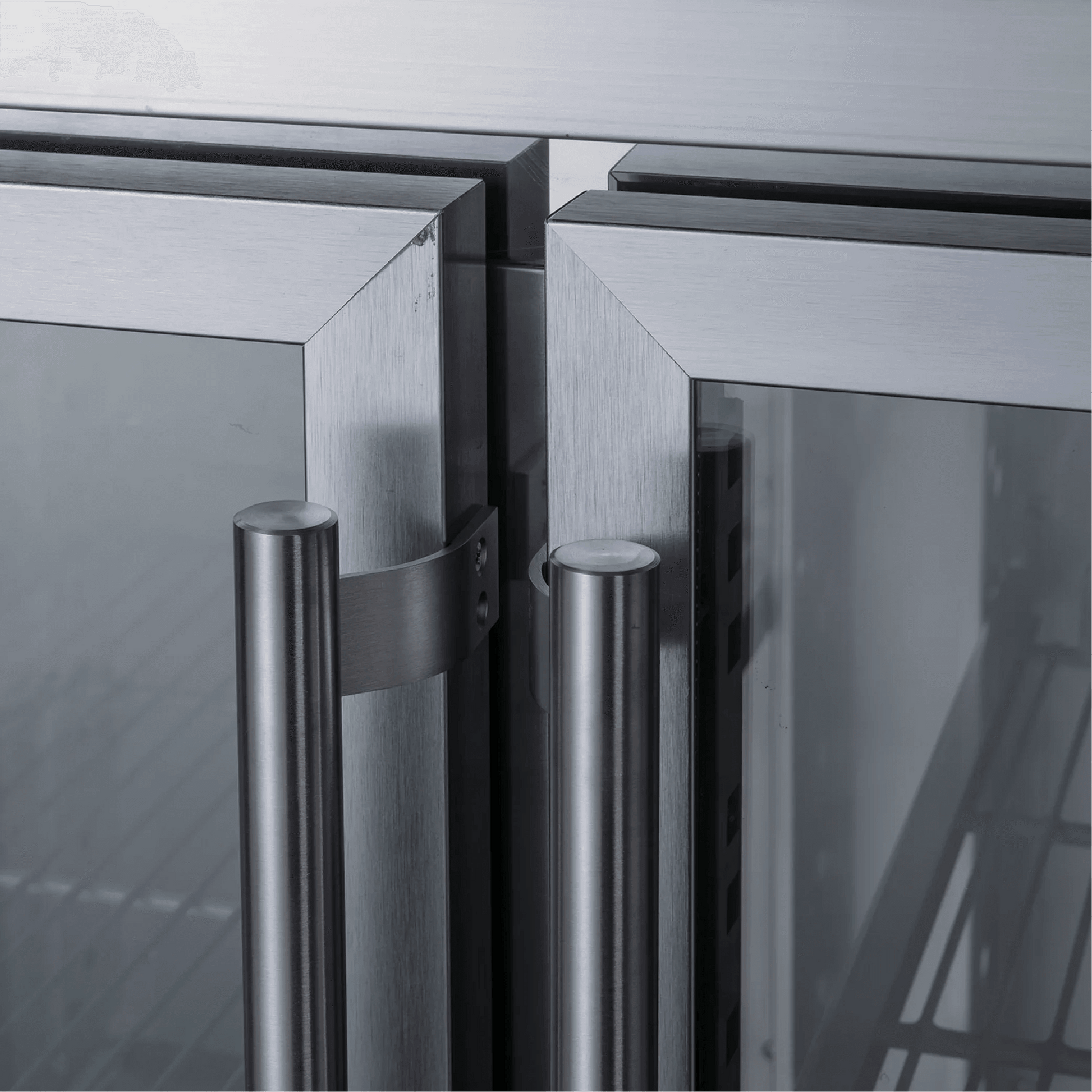 Stainless steel underbench refrigerator with three glass doors and vertical tubular handles.