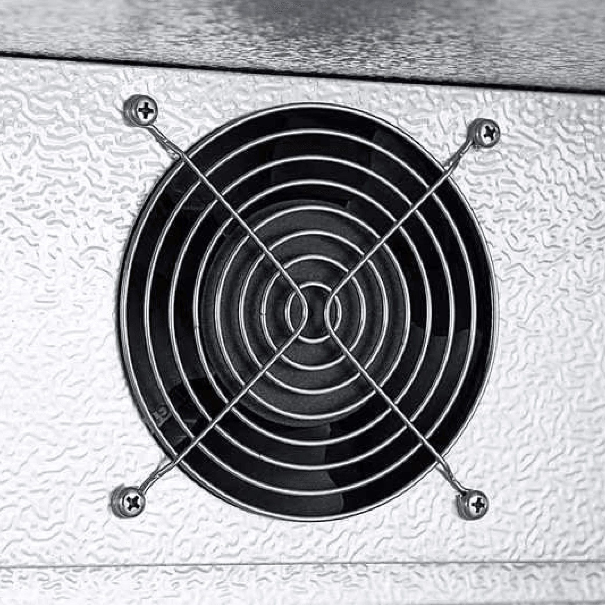 Close-up of round black ventilation grille with metal protective crossbars on textured silver metal surface.