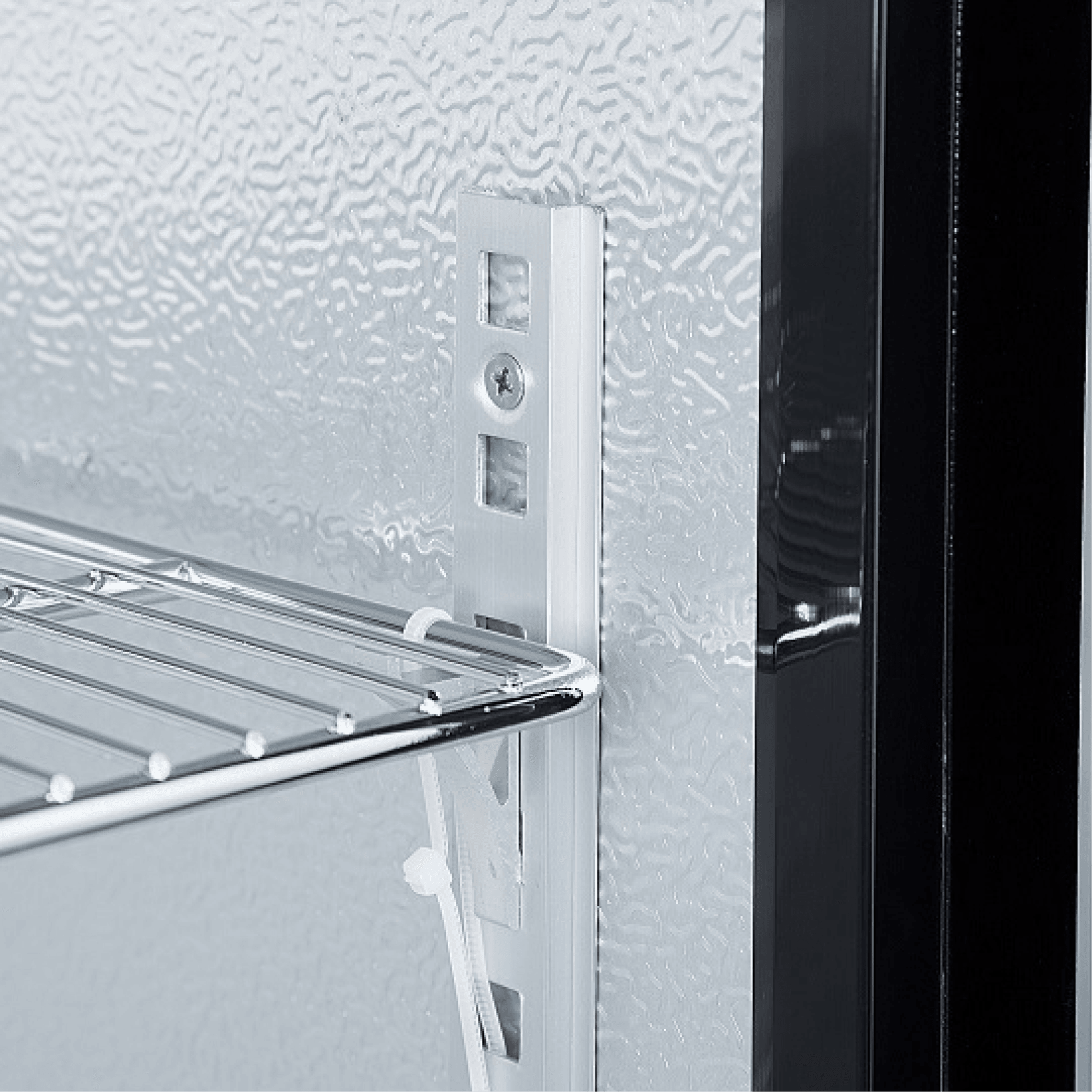 Close-up of white painted steel interior with adjustable chrome wire shelf and vertical slot support in glass door backbar.