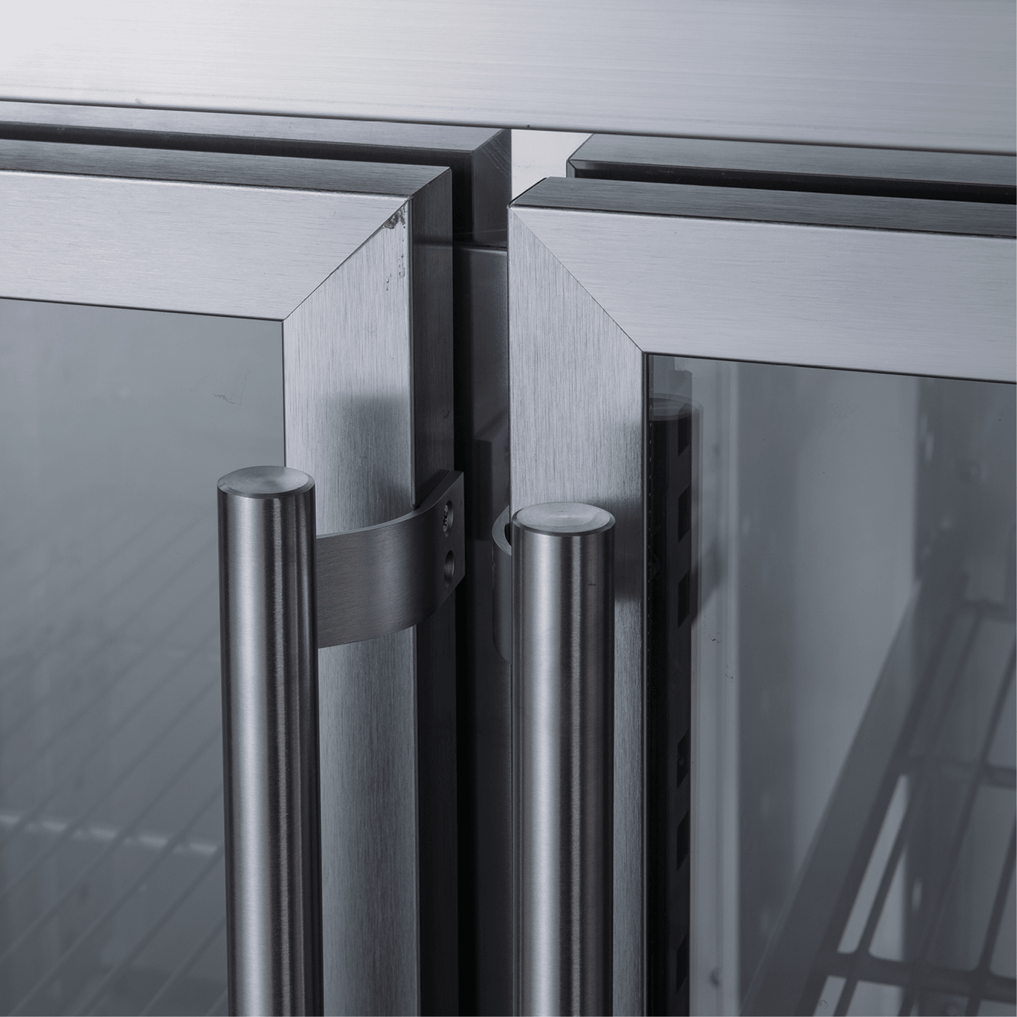Stainless steel four-door underbench refrigerator with glass panels and vertical handles.