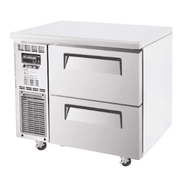 Compact stainless steel underbench fridge with two pull-out drawers and ventilation panel on side.