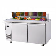 Stainless steel two-door salad prep table with clear sneeze guard and colorful fresh vegetables inside.